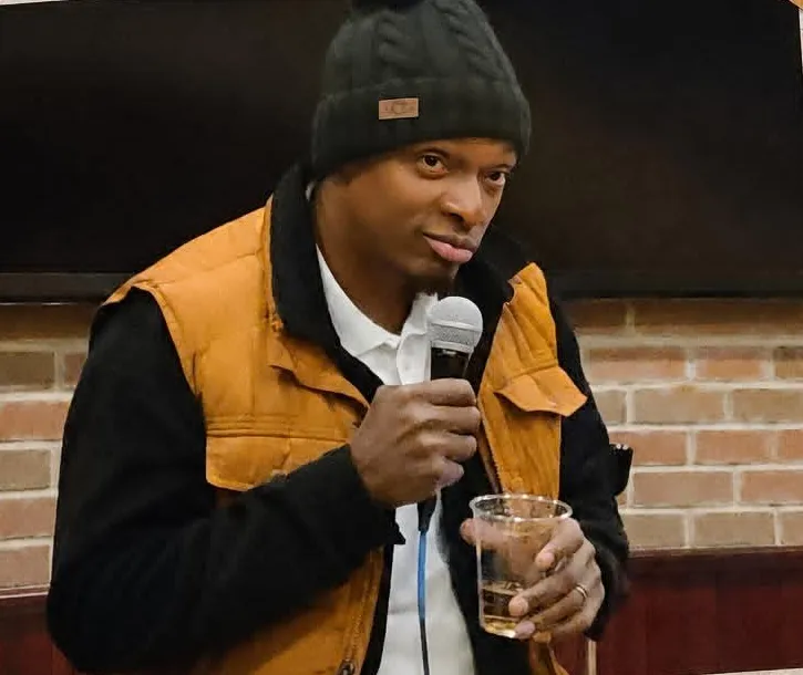 Foster Nicholson performing stand-up with a microphone